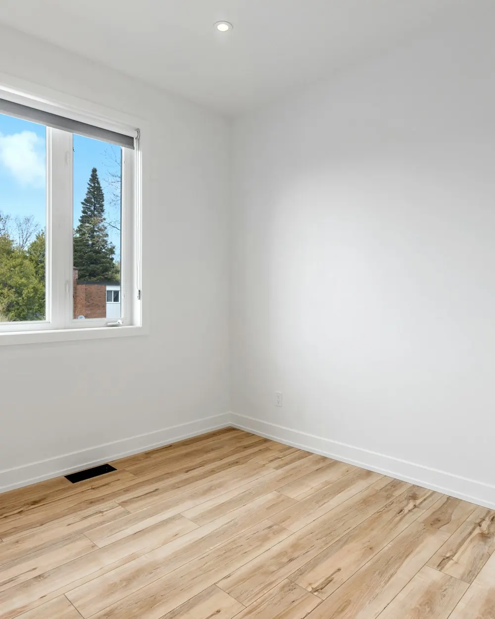 Empty room with freshly painted white walls and a wood floor