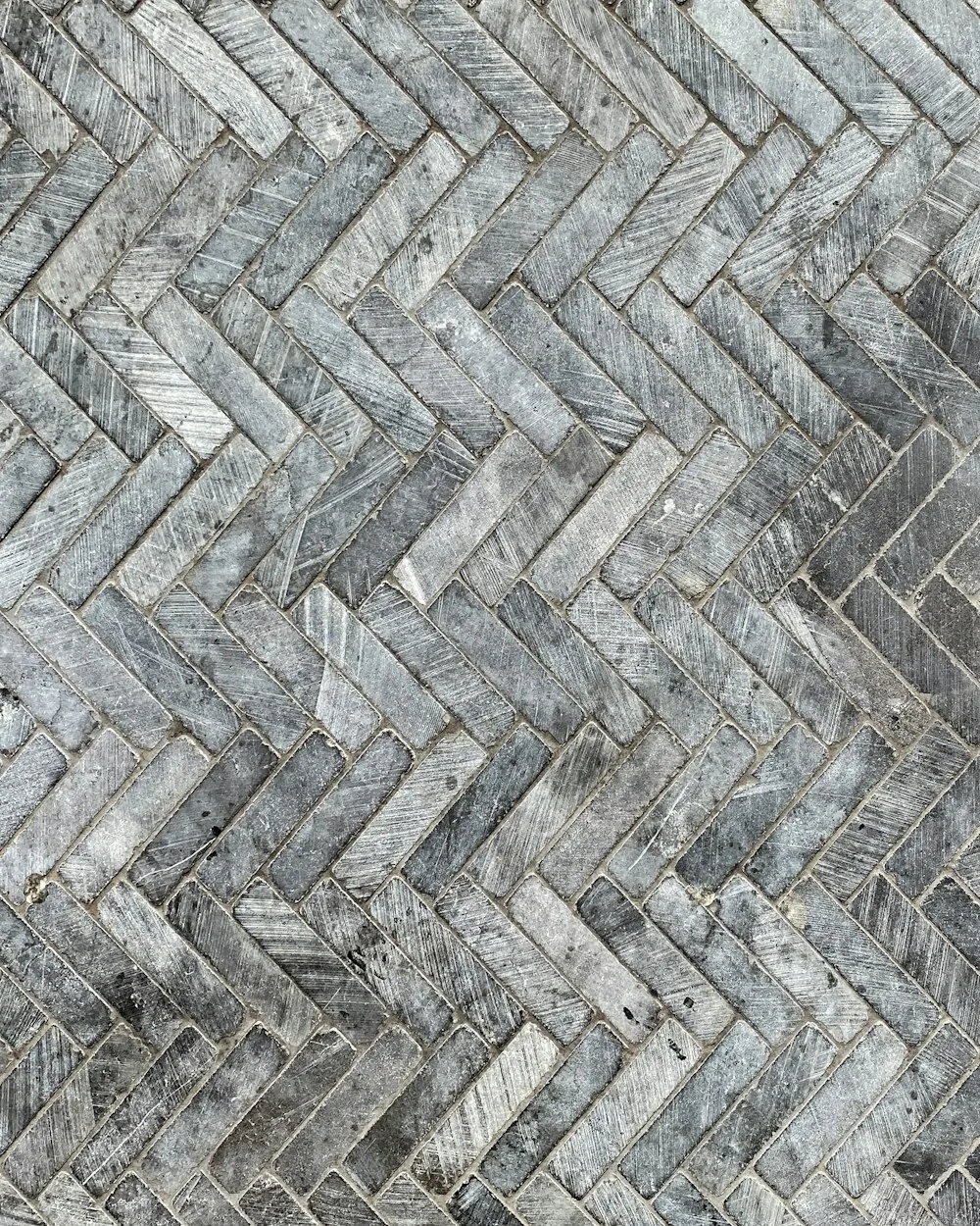 Gray marble tile floor laid in a herringbone pattern
