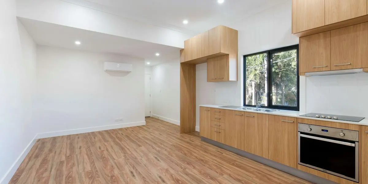 Light wood flooring installed through an open kitchen and living space