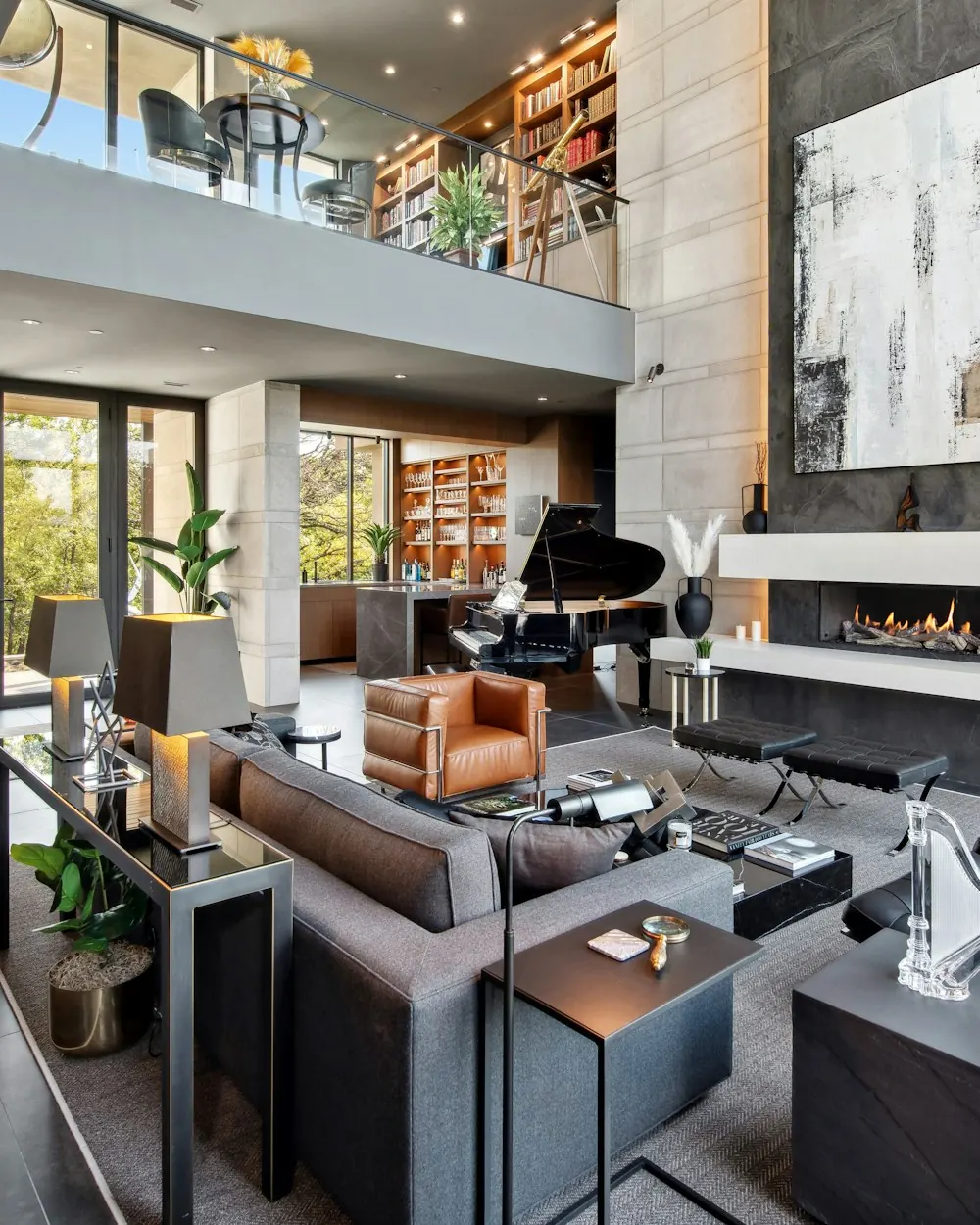 Double-height living room with a stone fireplace wall and modern furniture