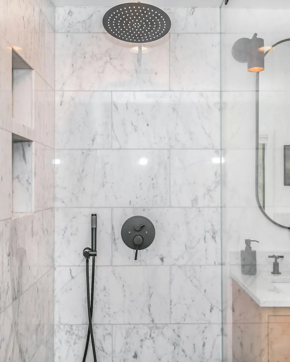 Marble walk-in shower with a rain showerhead and built-in niche