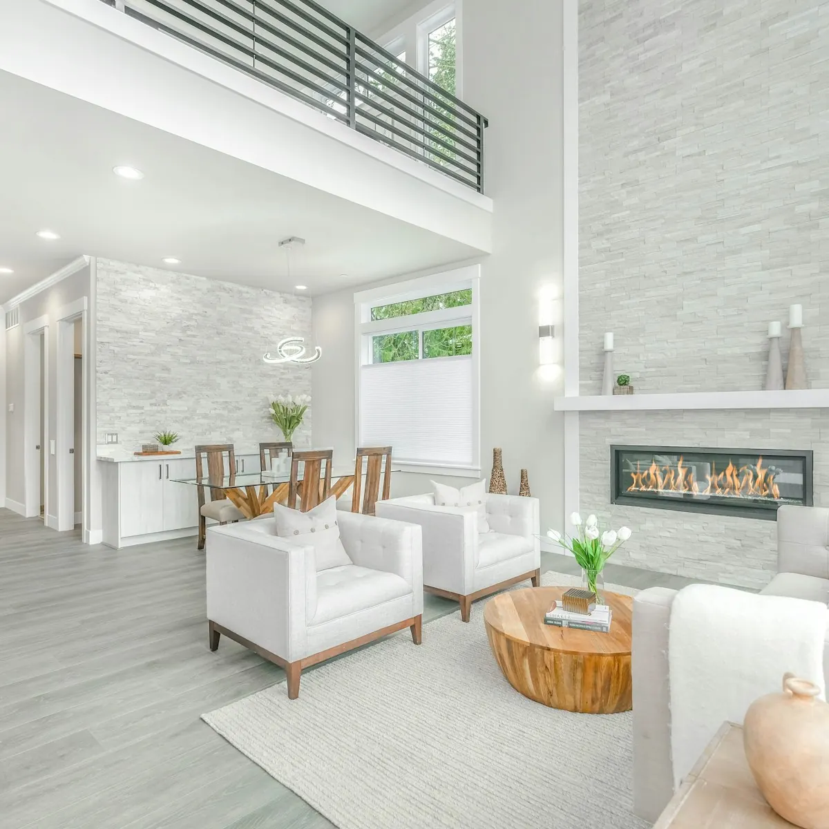 Renovated open living room with a linear fireplace and white furniture