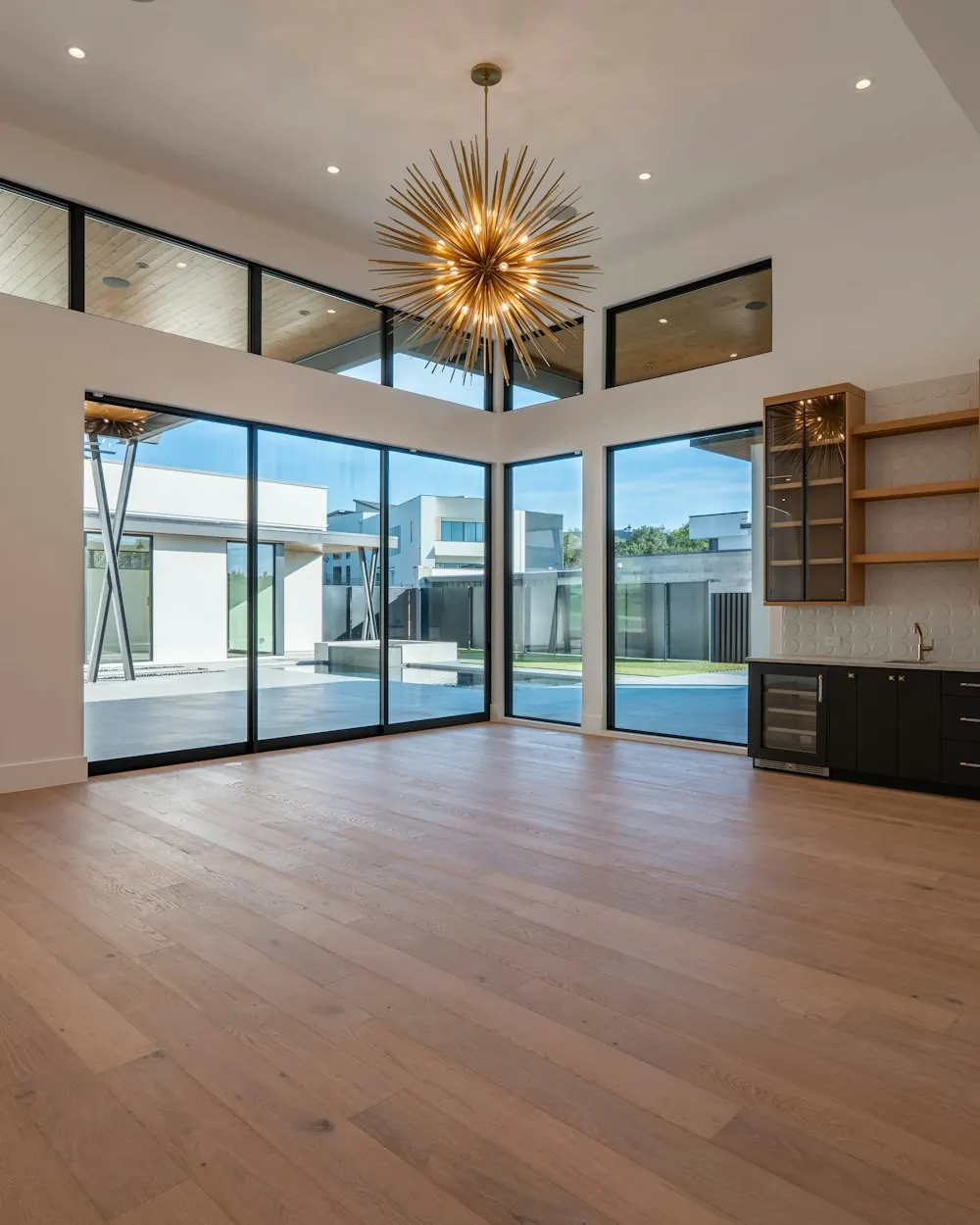 Wide-plank oak flooring in a large great room with tall windows